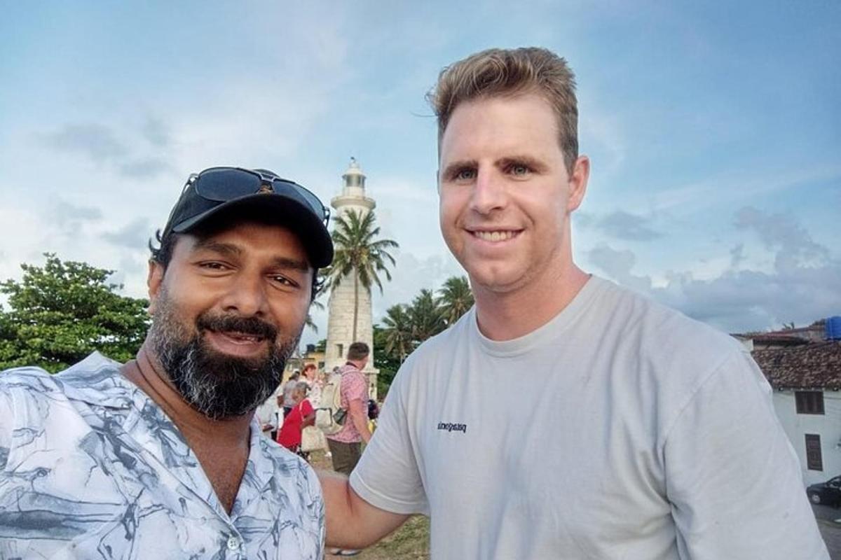 dua pria berpose untuk foto di depan masjid