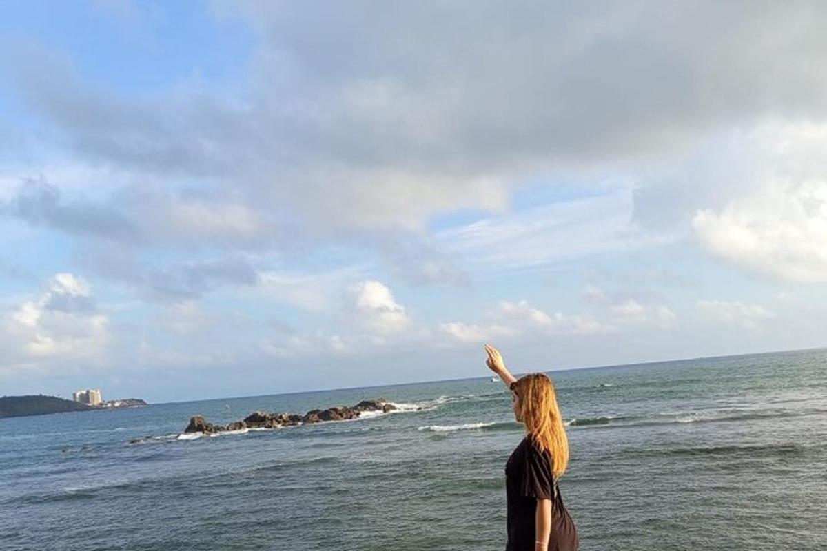 seorang wanita berdiri di pantai menerbangkan layang-layang