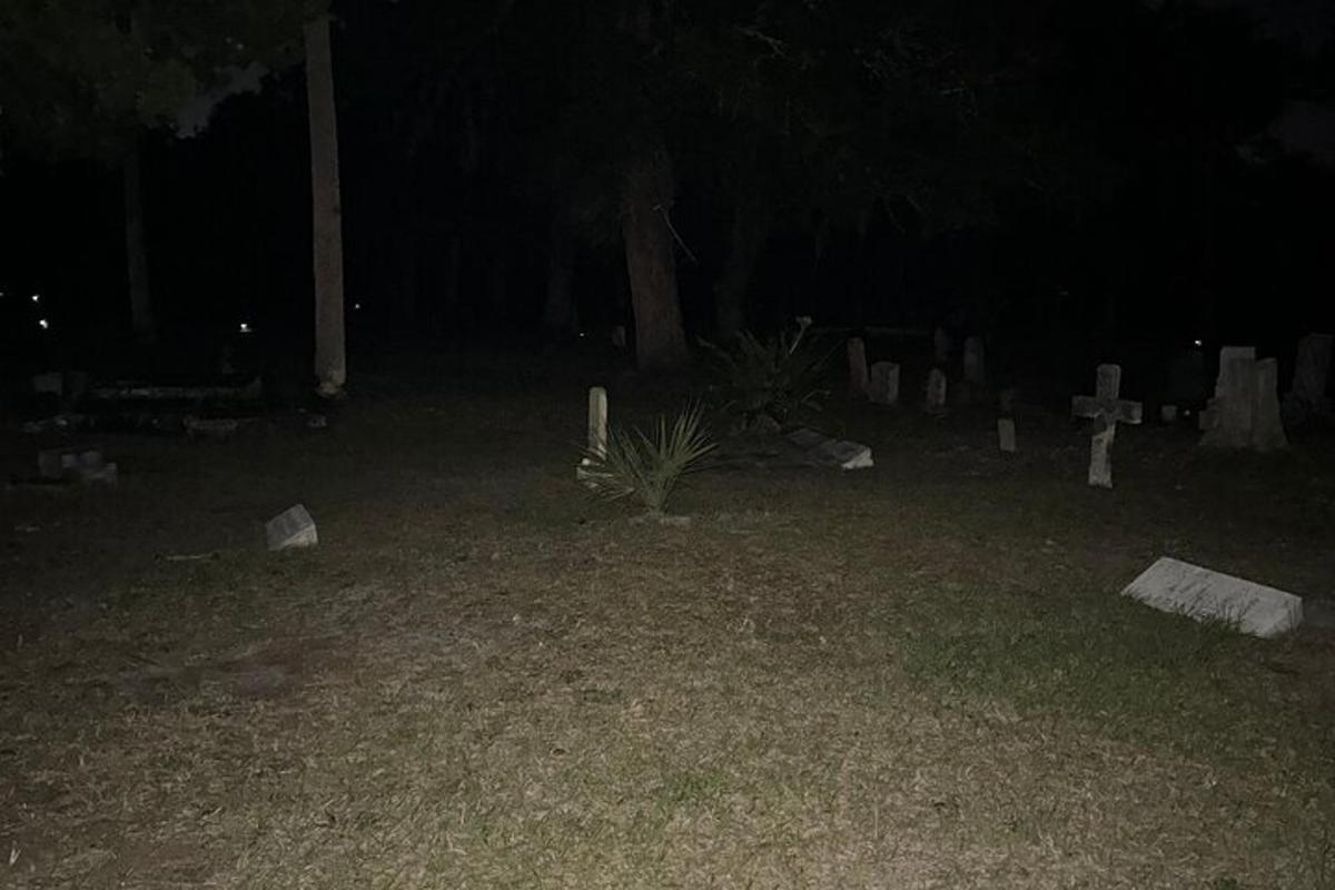 tanah perkuburan pada waktu malam dengan tumbuhan di rumput