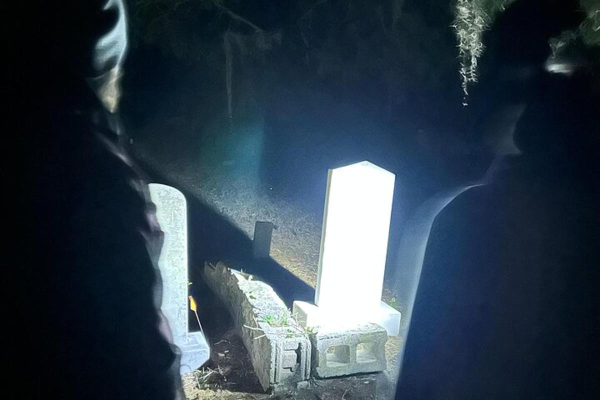 lilin yang menyala duduk di atas kubur