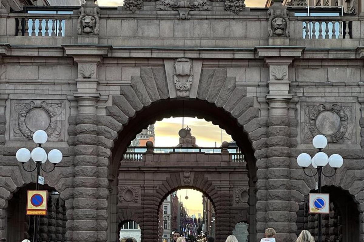 a stone bridge with two arches and people walking under it