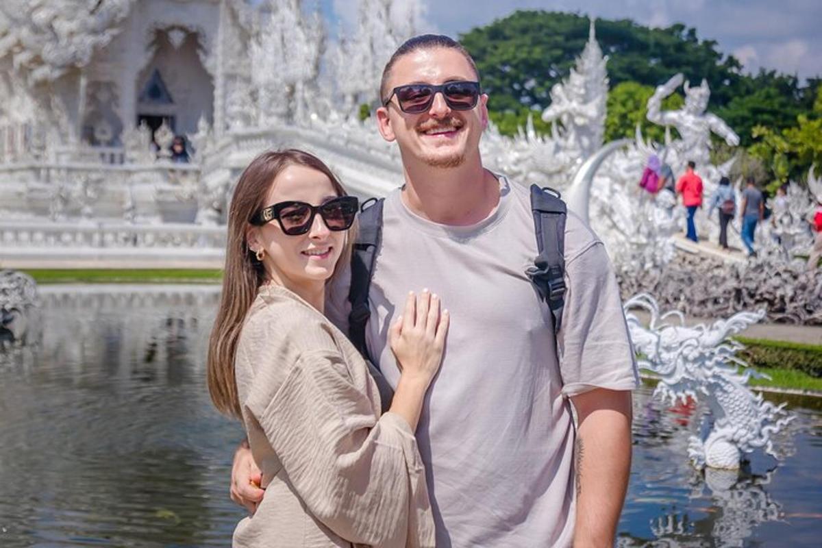 moški in ženska stojita pred vodnjakom