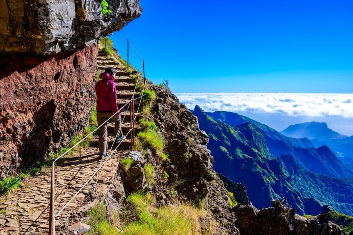 seseorang yang berdiri di atas denai di atas gunung