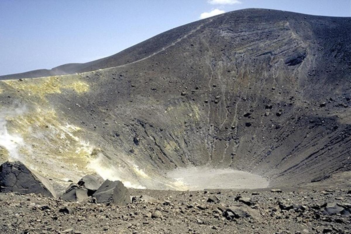 a large rock on a hill with a mountain
