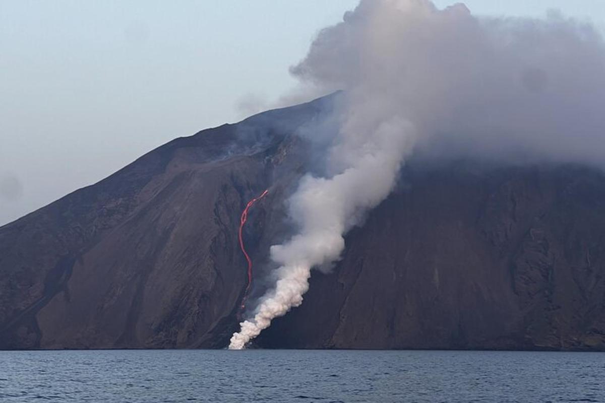 a volcano with smoke coming out of the side of a mountain