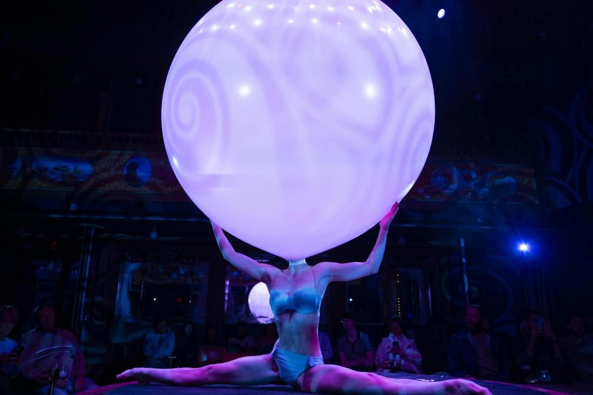 a person is holding a large balloon on a stage