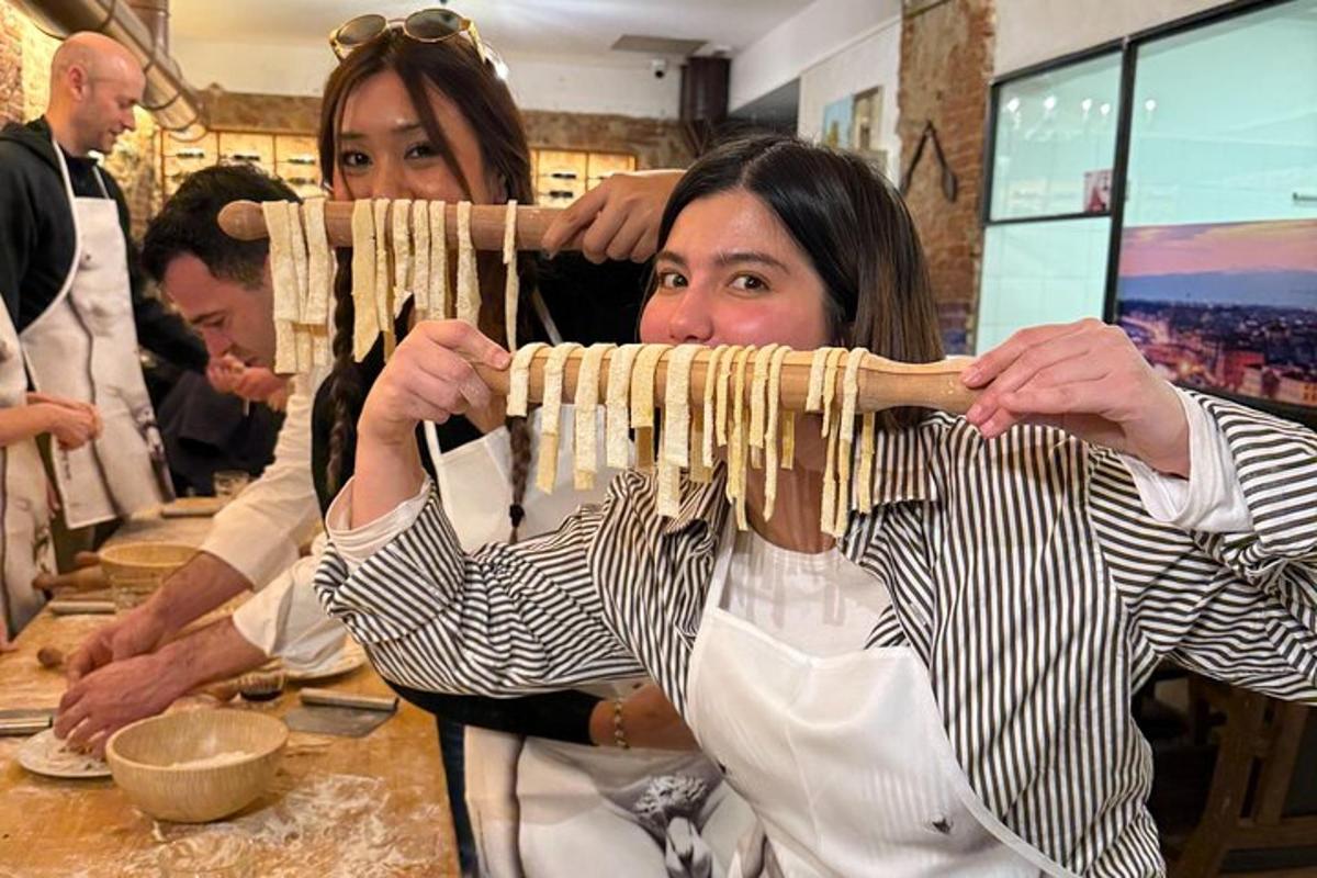 Dos mujeres sostienen un montón de pasta.