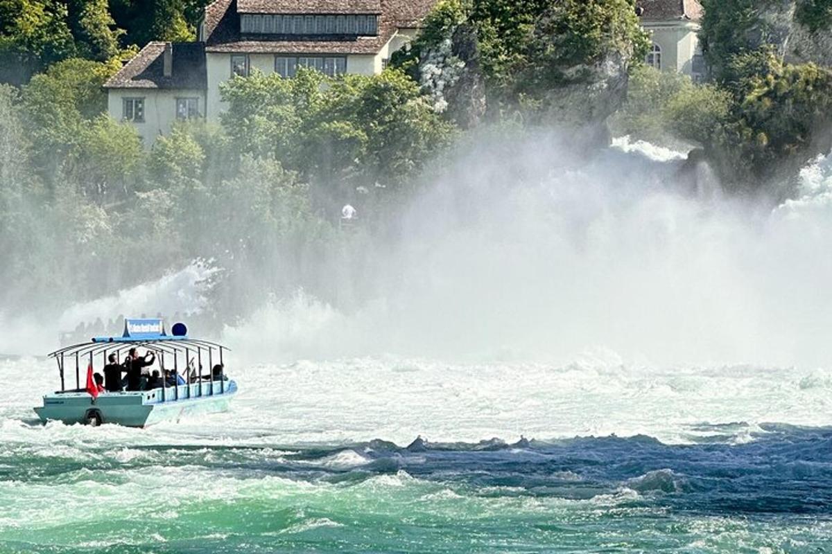 ein Boot im Wasser in der Nähe eines großen Wasserfalls