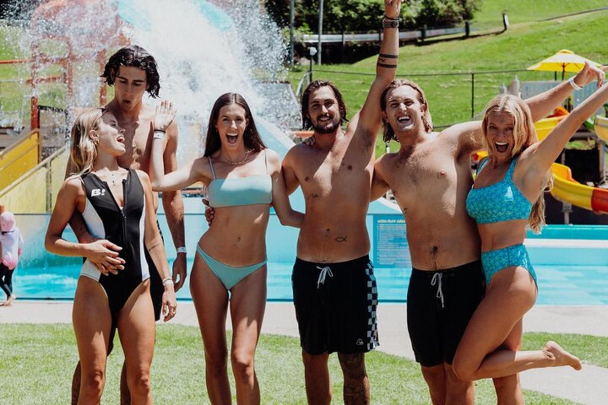 eine Gruppe von Menschen steht vor einem Swimmingpool