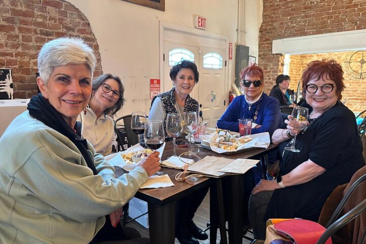 a group of women sitting at a table with wine glasses
