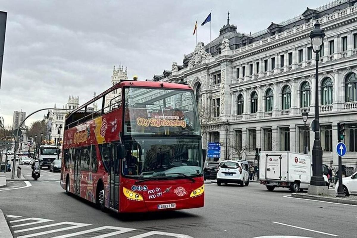 červený dvoupatrový autobus jedoucí po městské ulici