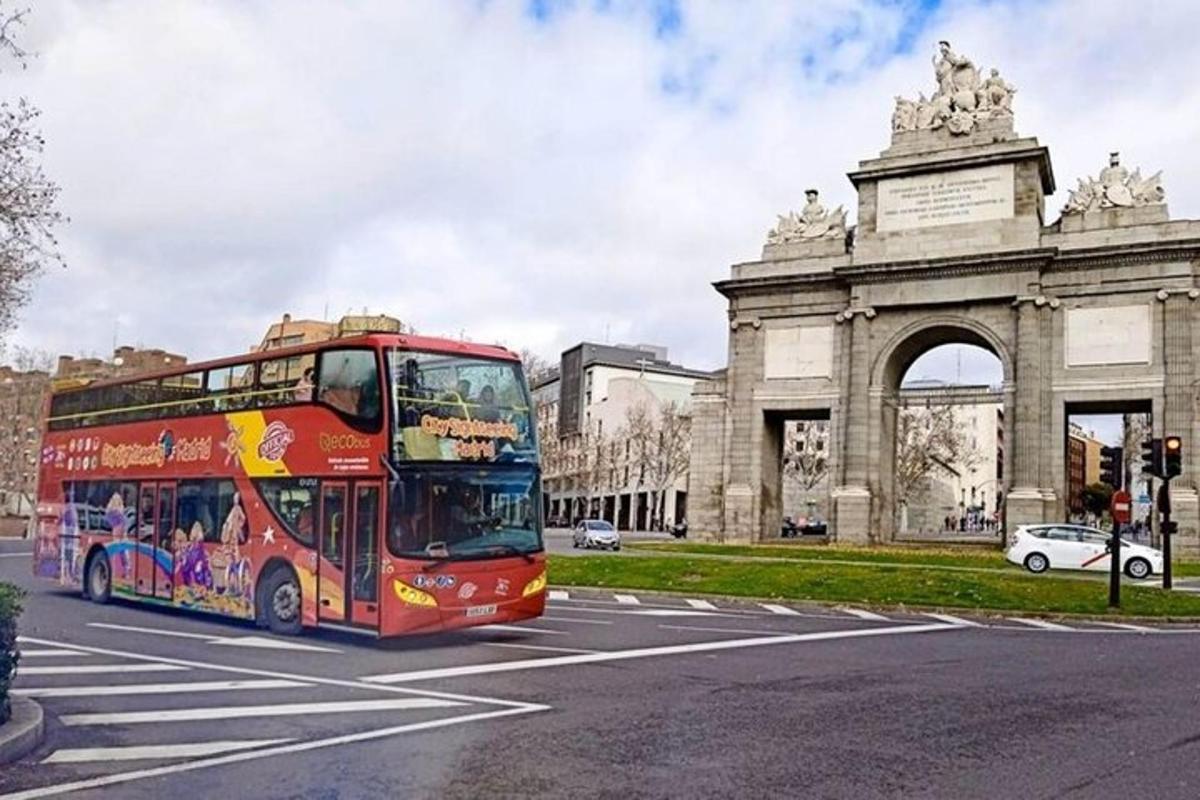 červený dvoupatrový autobus projíždějící kolem budovy