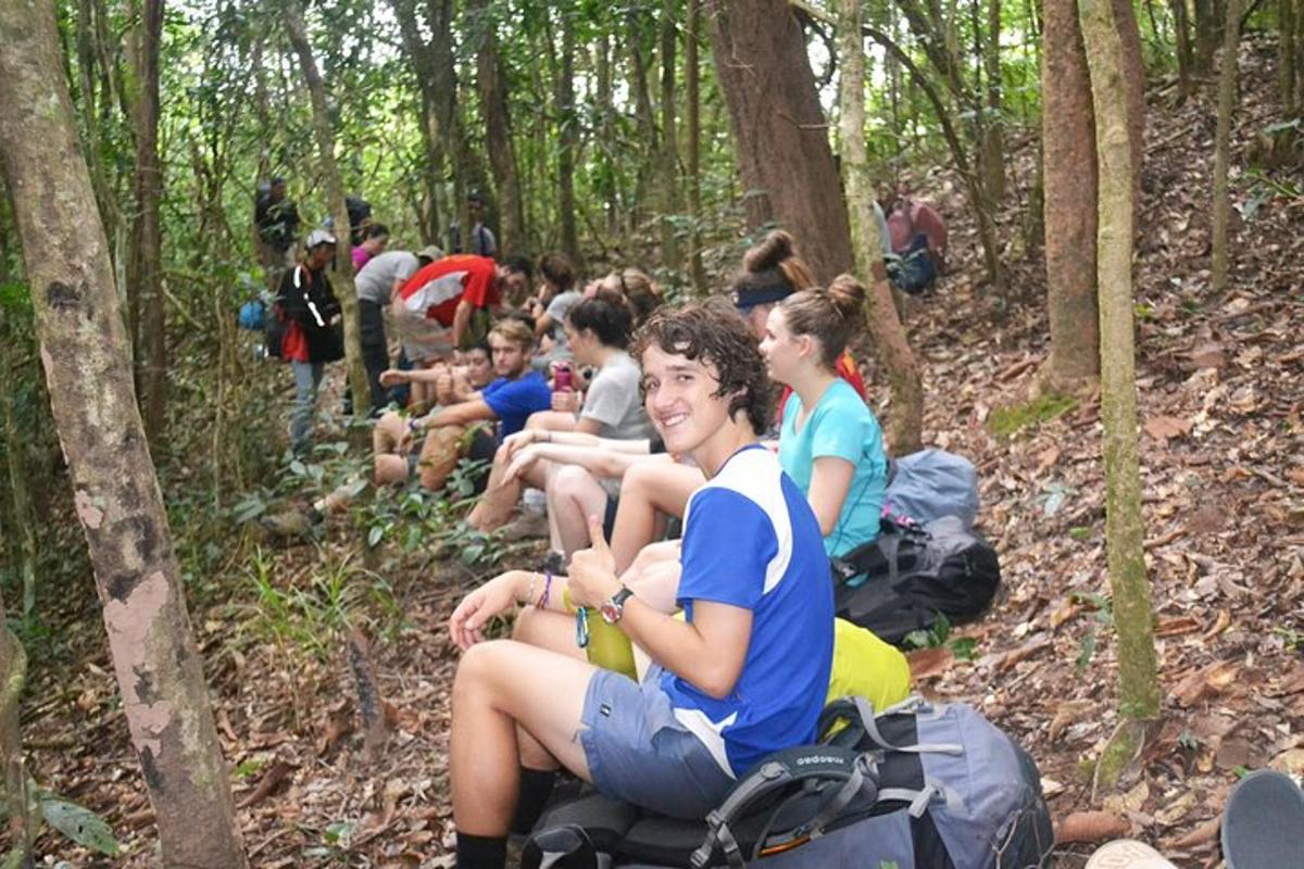 a group of people sitting on bags in the woods