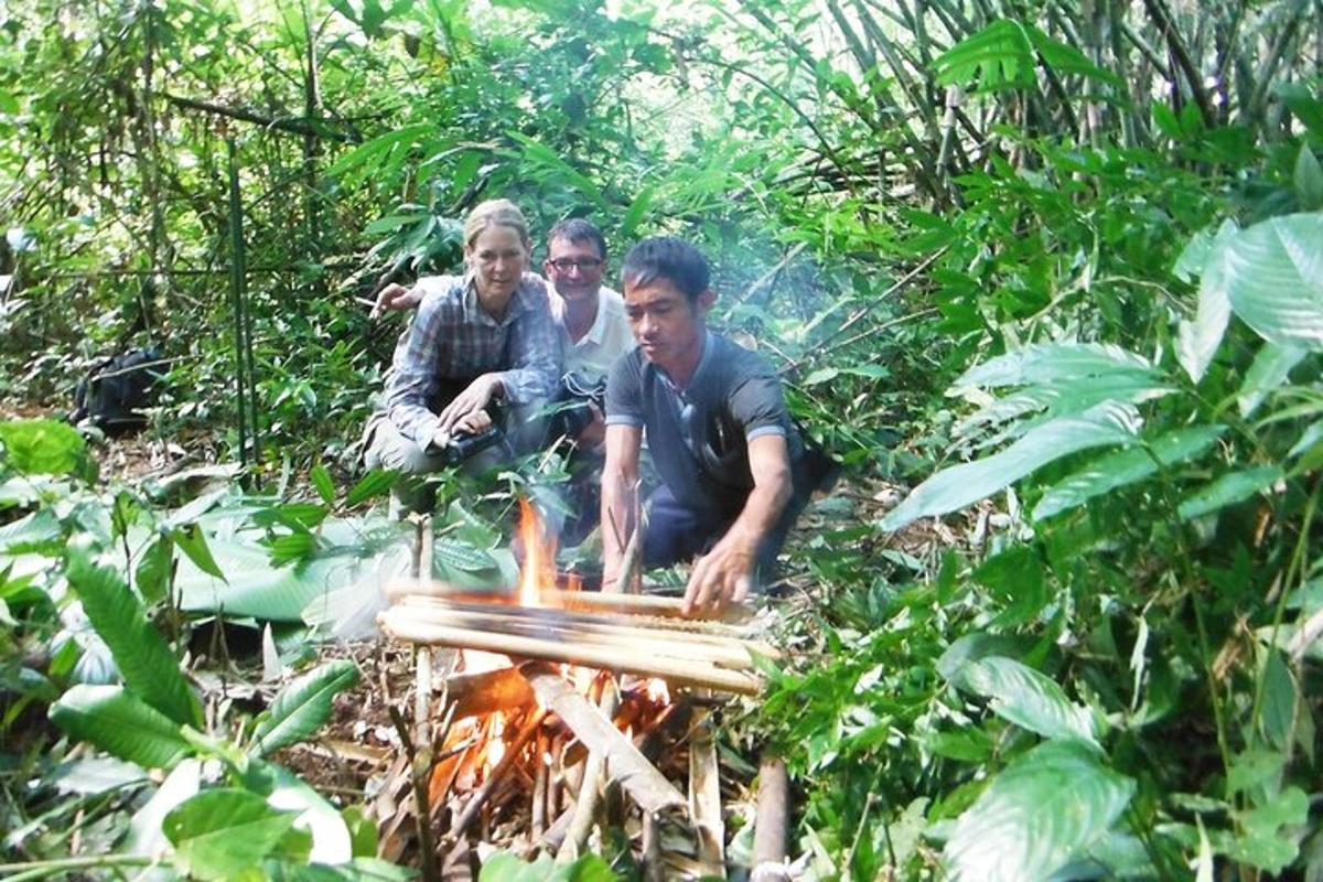 three men sitting around a fire in the forest