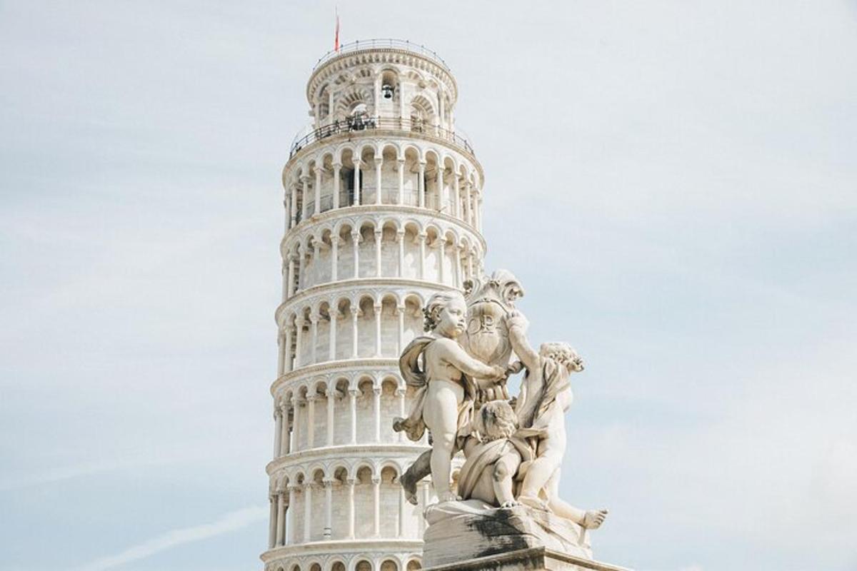 sebuah patung di hadapan menara condong