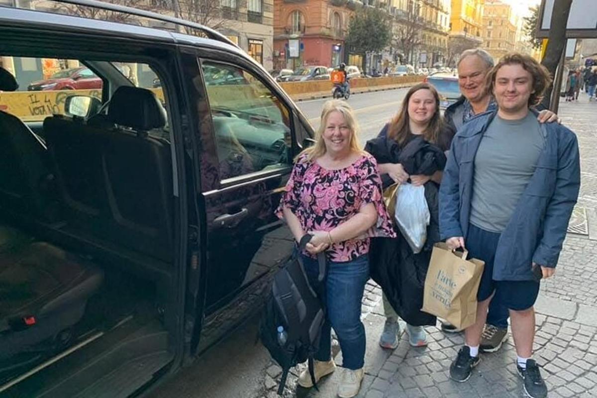 Un grupo de personas de pie junto a un coche.