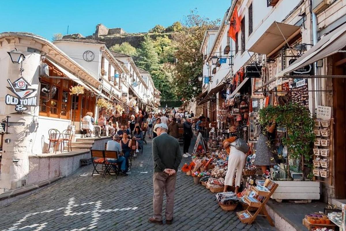 Un grupo de personas caminando por una calle con tiendas.