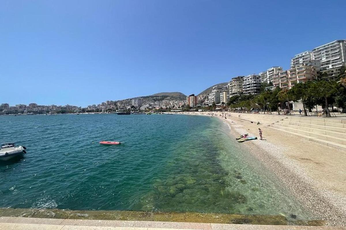 Una playa con dos barcos en el agua y edificios.