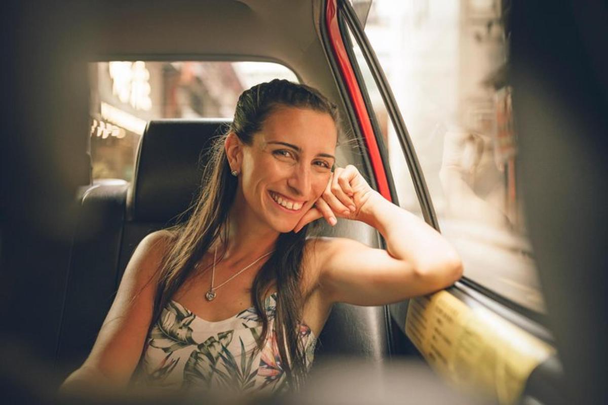 Una mujer sentada en un coche mirando a la cámara.