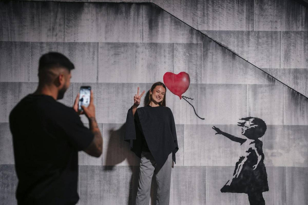 Un hombre tomando una foto de una mujer con un globo de corazón.
