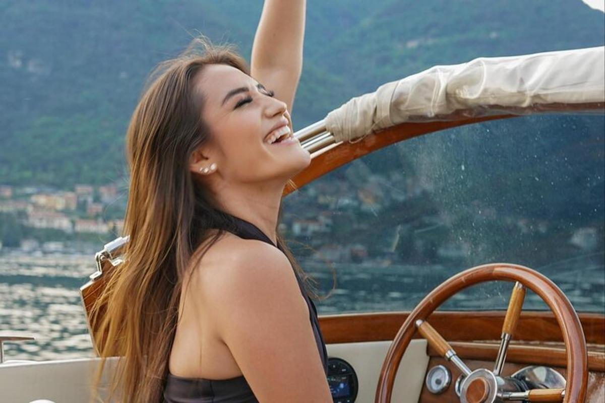 una dona asseguda en un vaixell amb la mà a l'aire