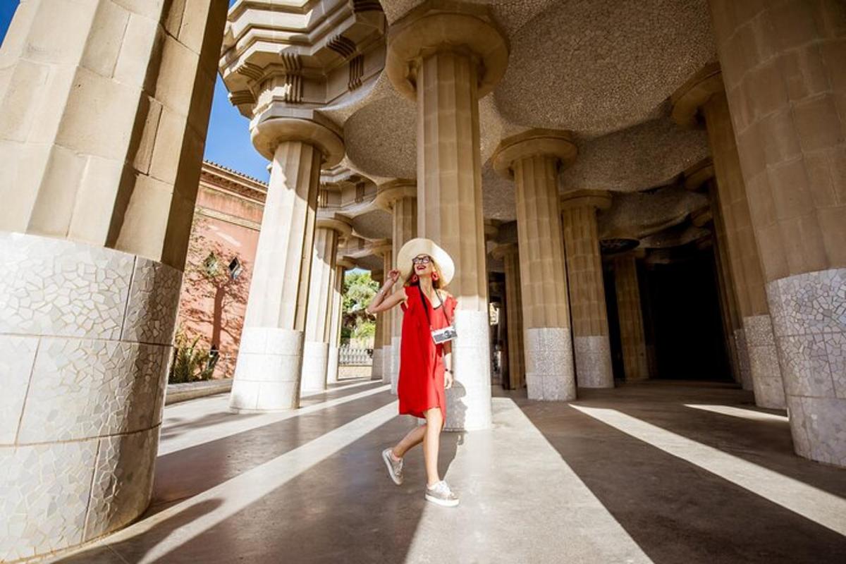 Una mujer con un vestido rojo y un sombrero parada en un edificio.
