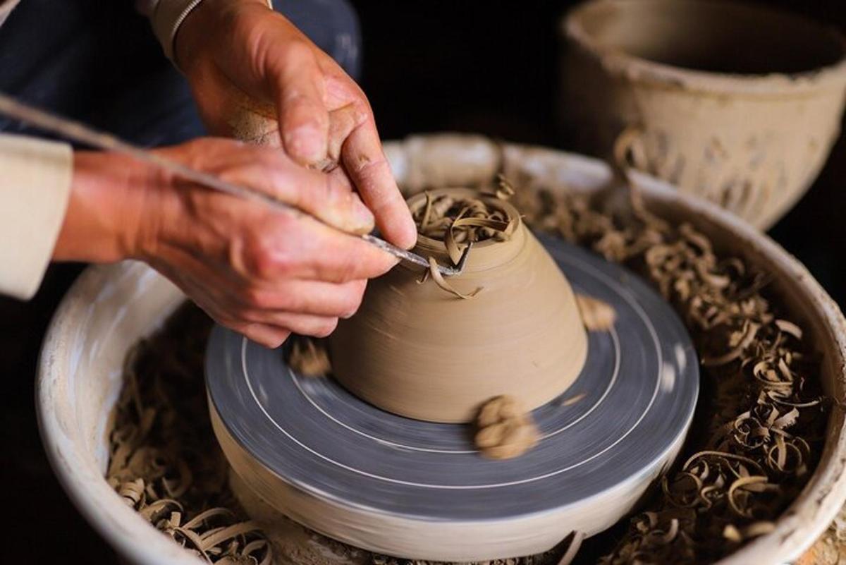 a person making a vase on a pottery wheel