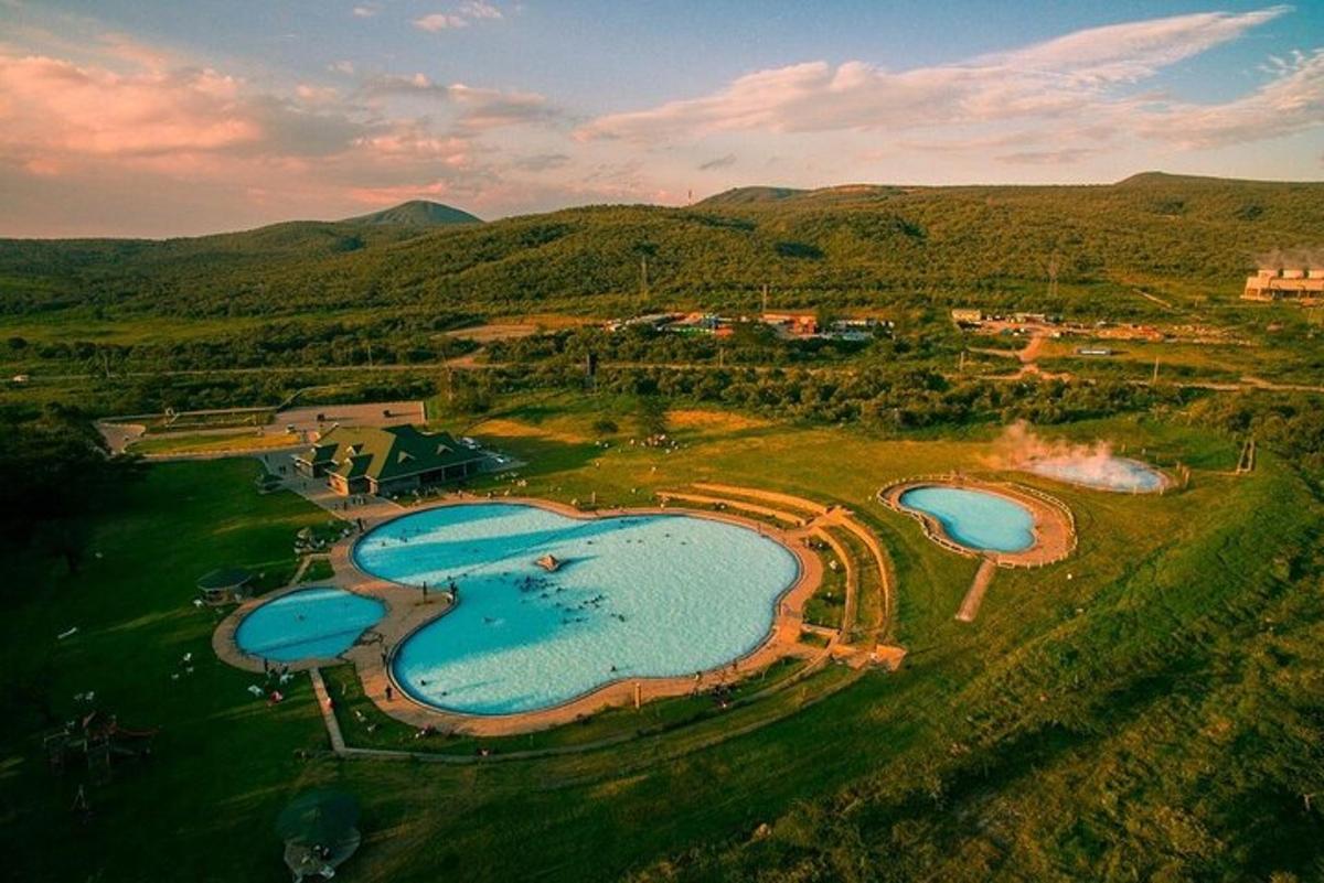 an aerial view of two swimming pools in a field