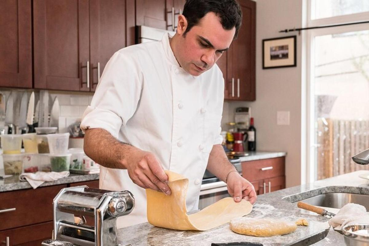 a man in a kitchen kneading a piece of dough