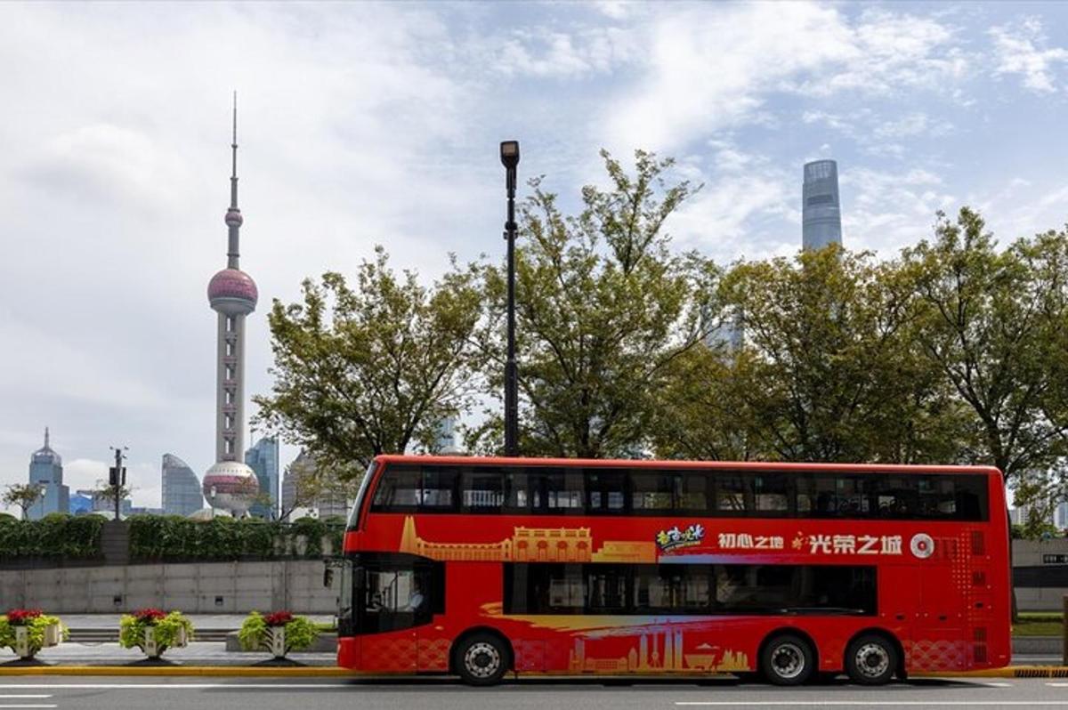 a red double decker bus driving down a street