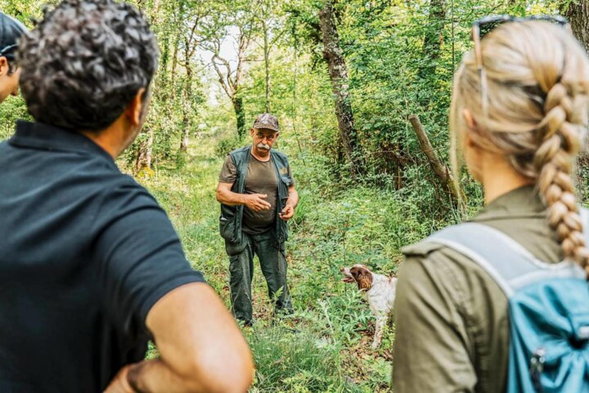 sekumpulan orang berdiri di dalam hutan bersama seorang lelaki