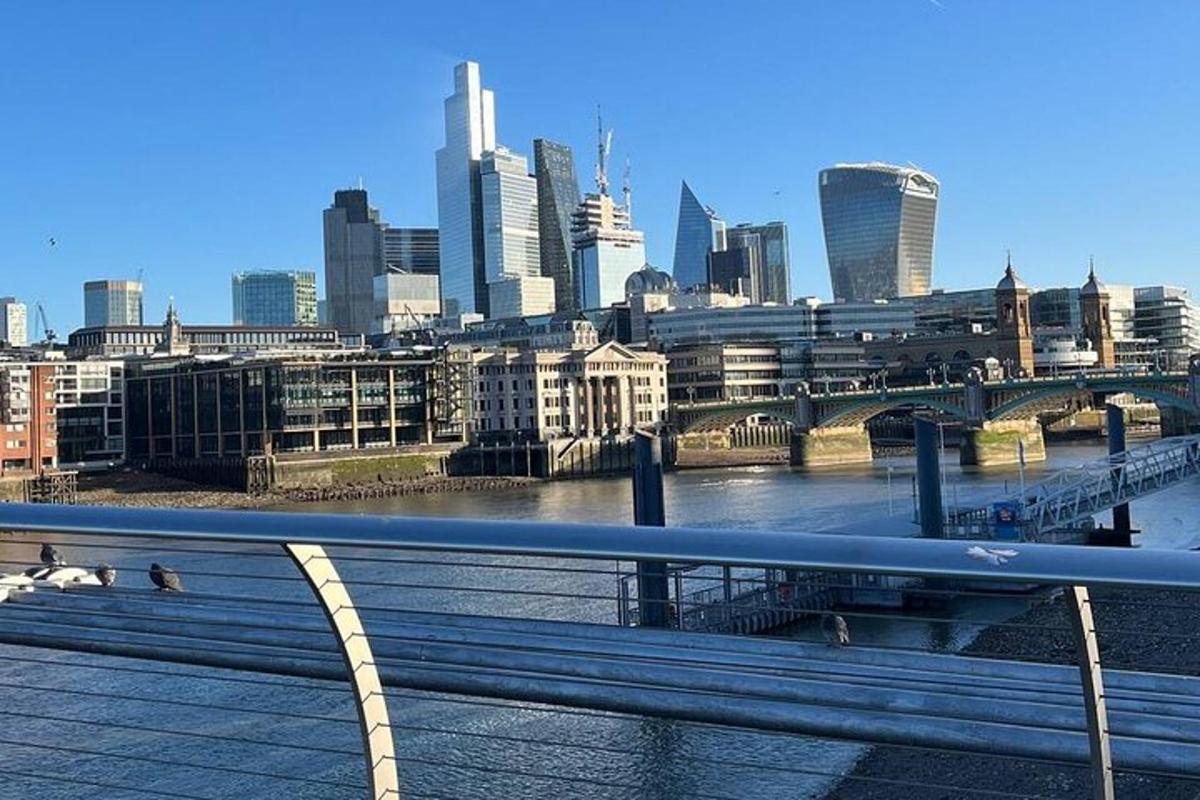a bench on a bridge over a river with a city
