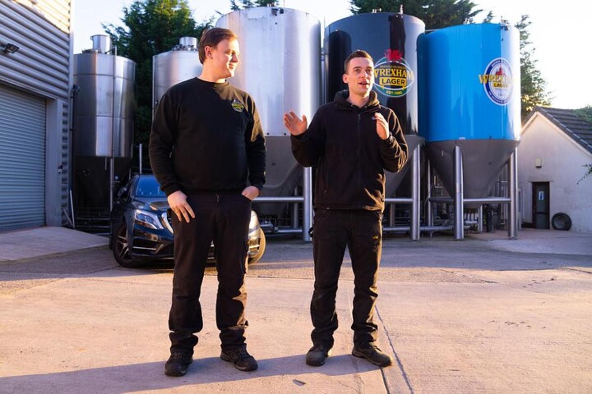 two men standing next to each other in a parking lot