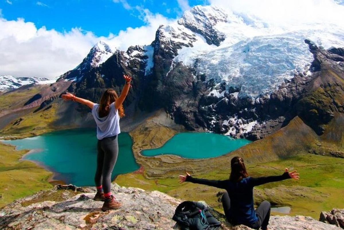 dua wanita berdiri di atas gunung dengan tangan dihulurkan