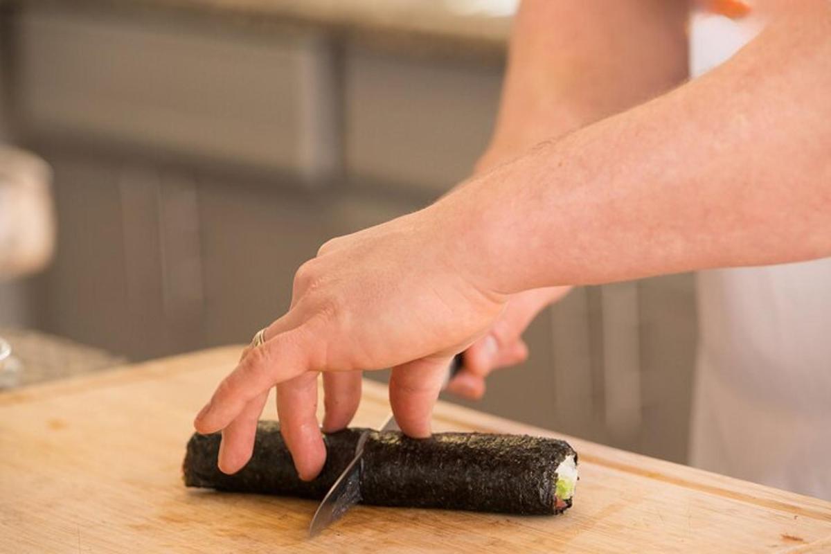 a person cutting a carrot on a cutting board