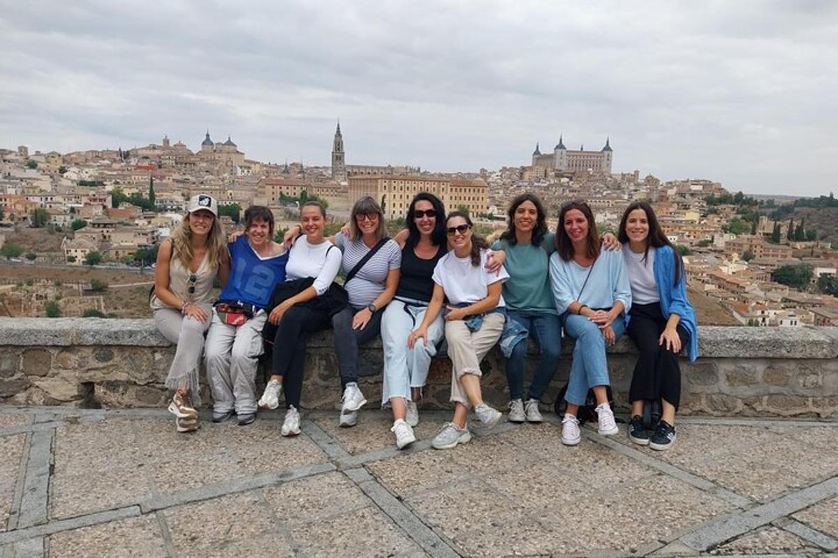 un gruppo di persone sedute su una sporgenza che domina una città