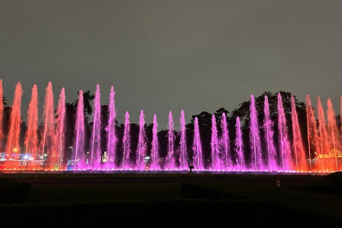 una fontana d'acqua con luci rosa e viola