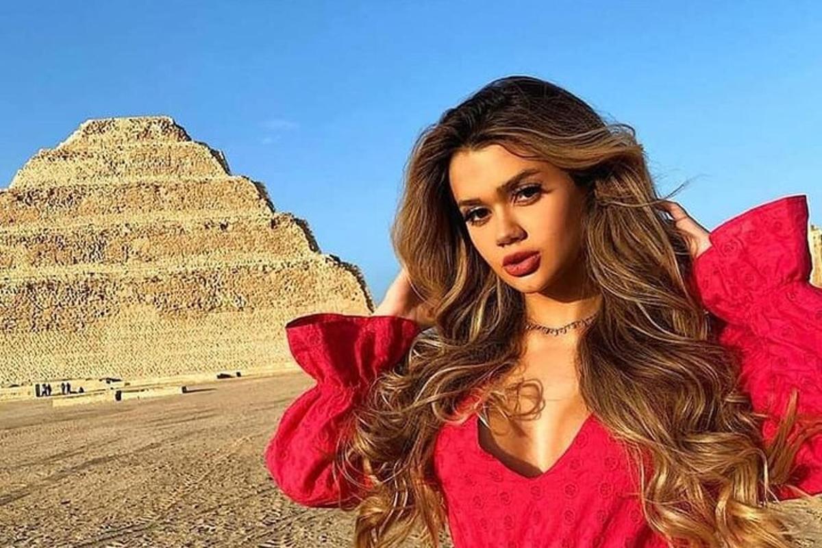 Žena stojí před pyramidou