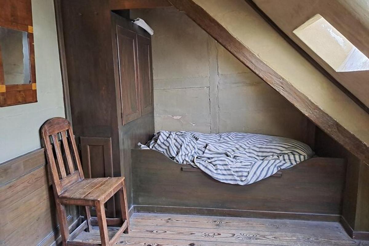 un letto in una stanza con una sedia e una porta di legno