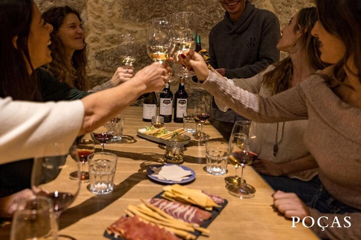 skupina lidí sedících kolem stolu s vinnými sklenicemi
