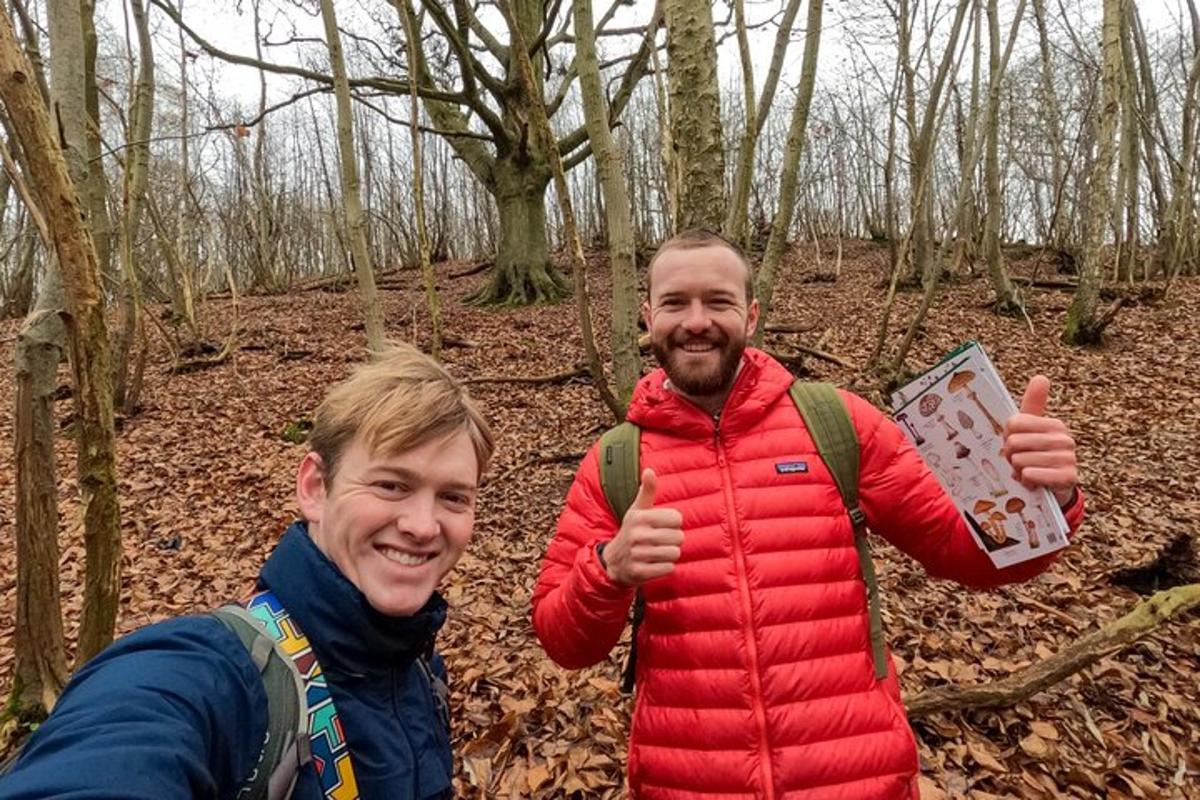 zwei Männer geben Daumen hoch, während sie im Wald stehen