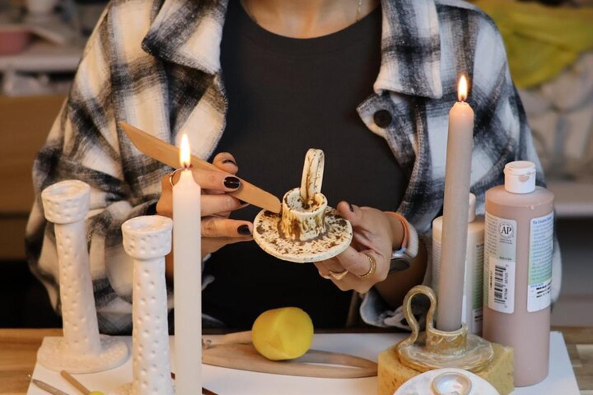 uma mulher cortando um bolo com velas em uma mesa