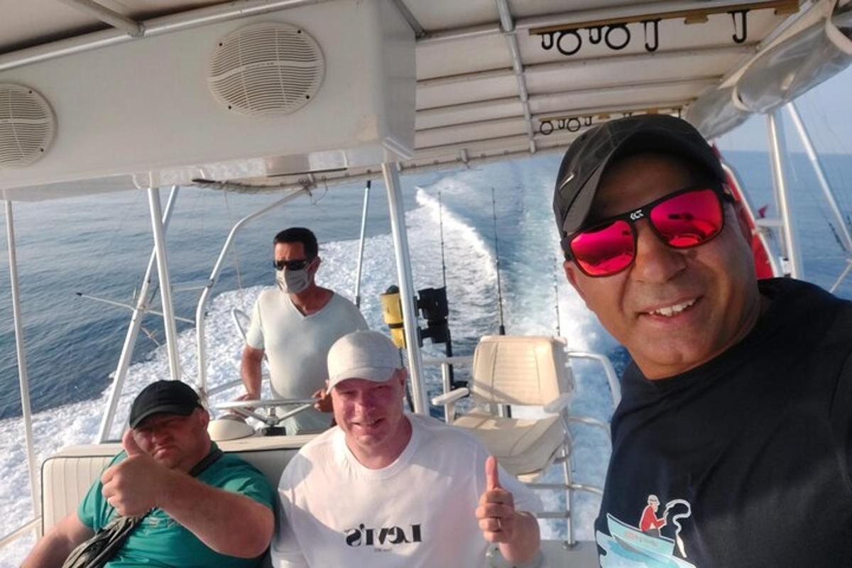 um grupo de homens em um barco fazendo sinal de positivo