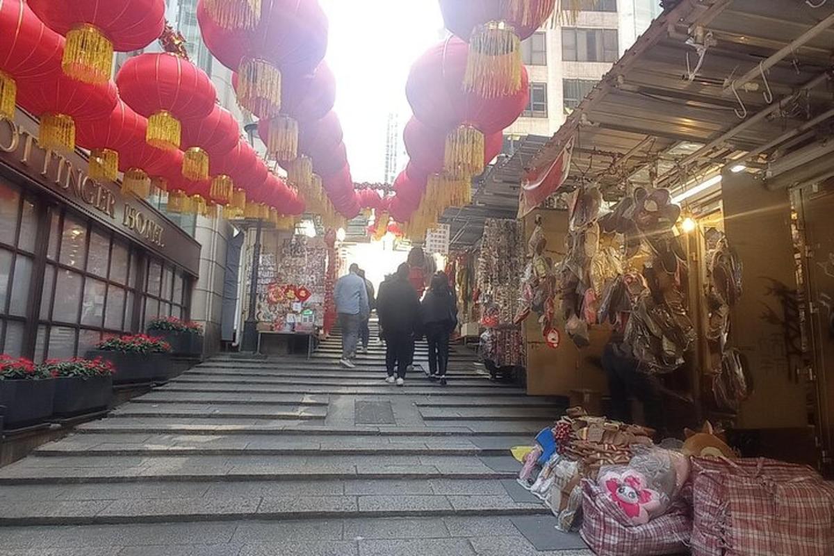 una strada con persone che camminano in un mercato con lanterne