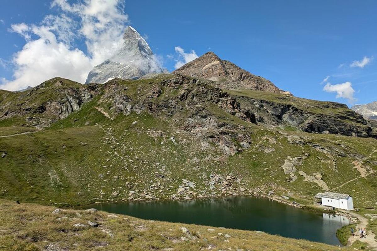 a house on the side of a mountain with a lake