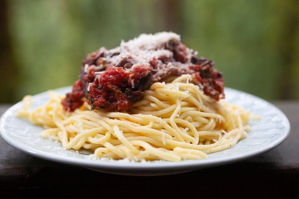 en tallerken med spaghetti med kjøttsaus på toppen