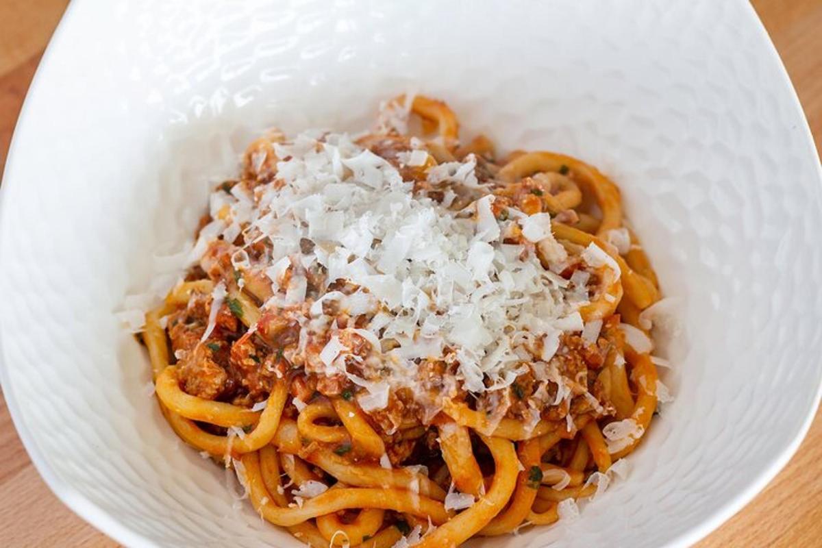 en hvit bolle med pasta med ost på et bord