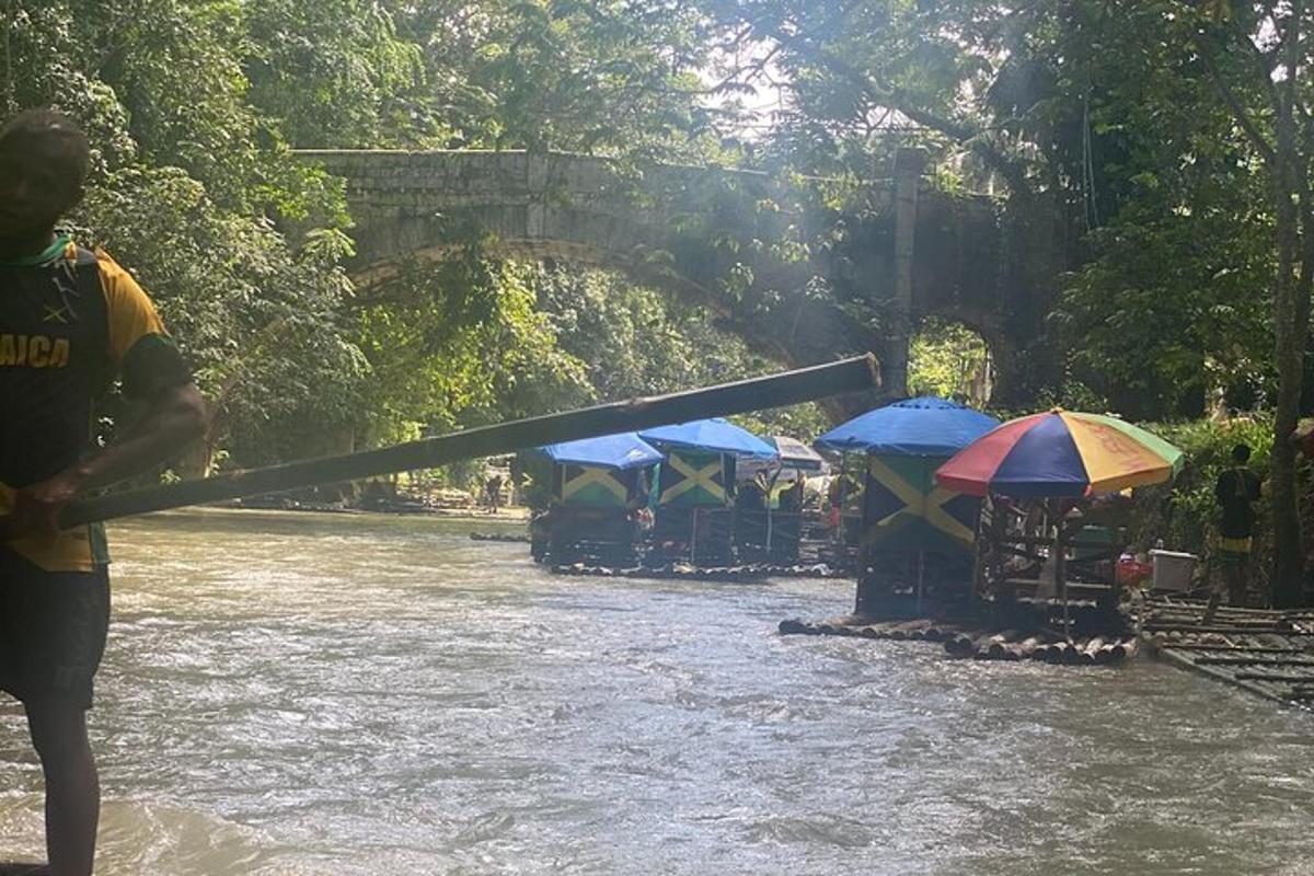 seorang lelaki memegang dayung di sungai dengan payung
