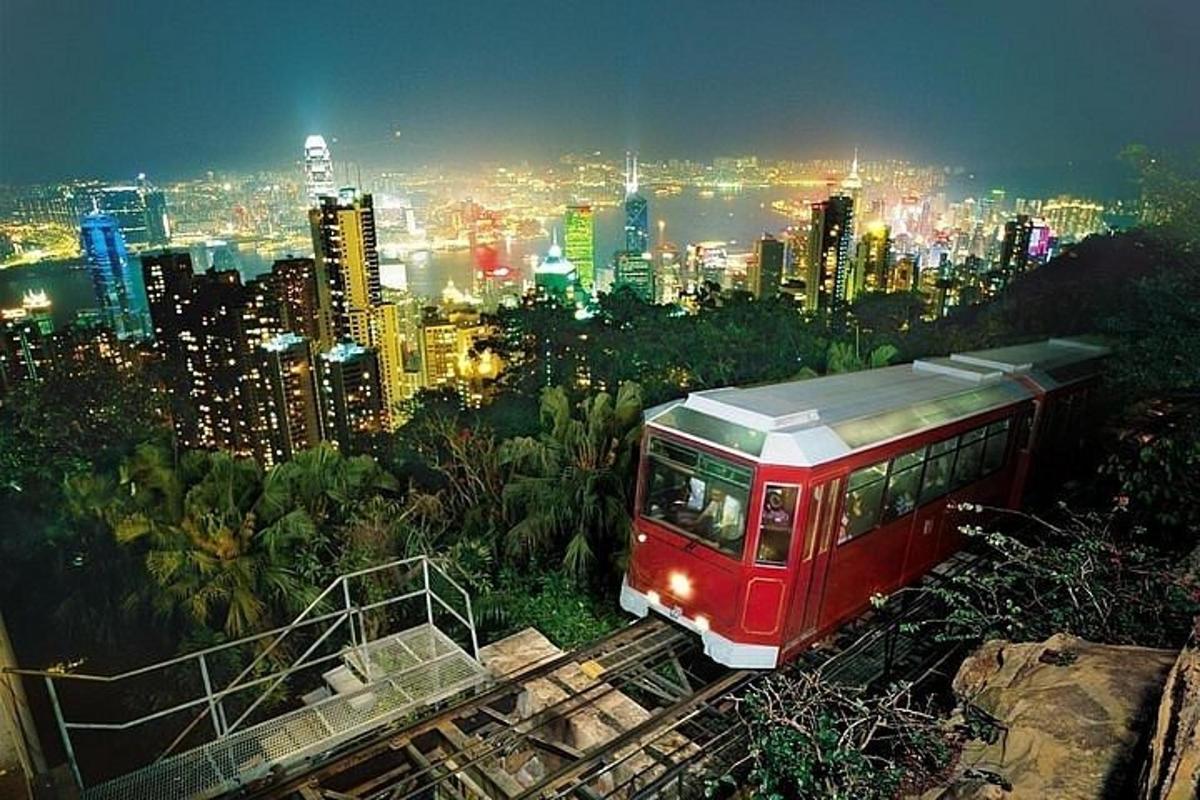 a red train on the tracks in front of a city