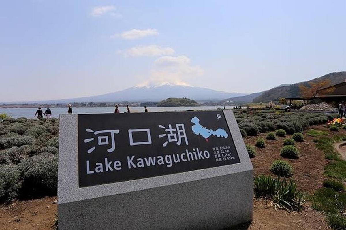a sign for a lake kawaguchiko with a mountain